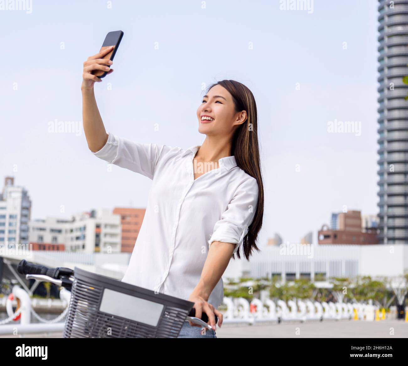 Junge Frau nimmt Selfie mit dem Smartphone im Stadtpark Stockfoto