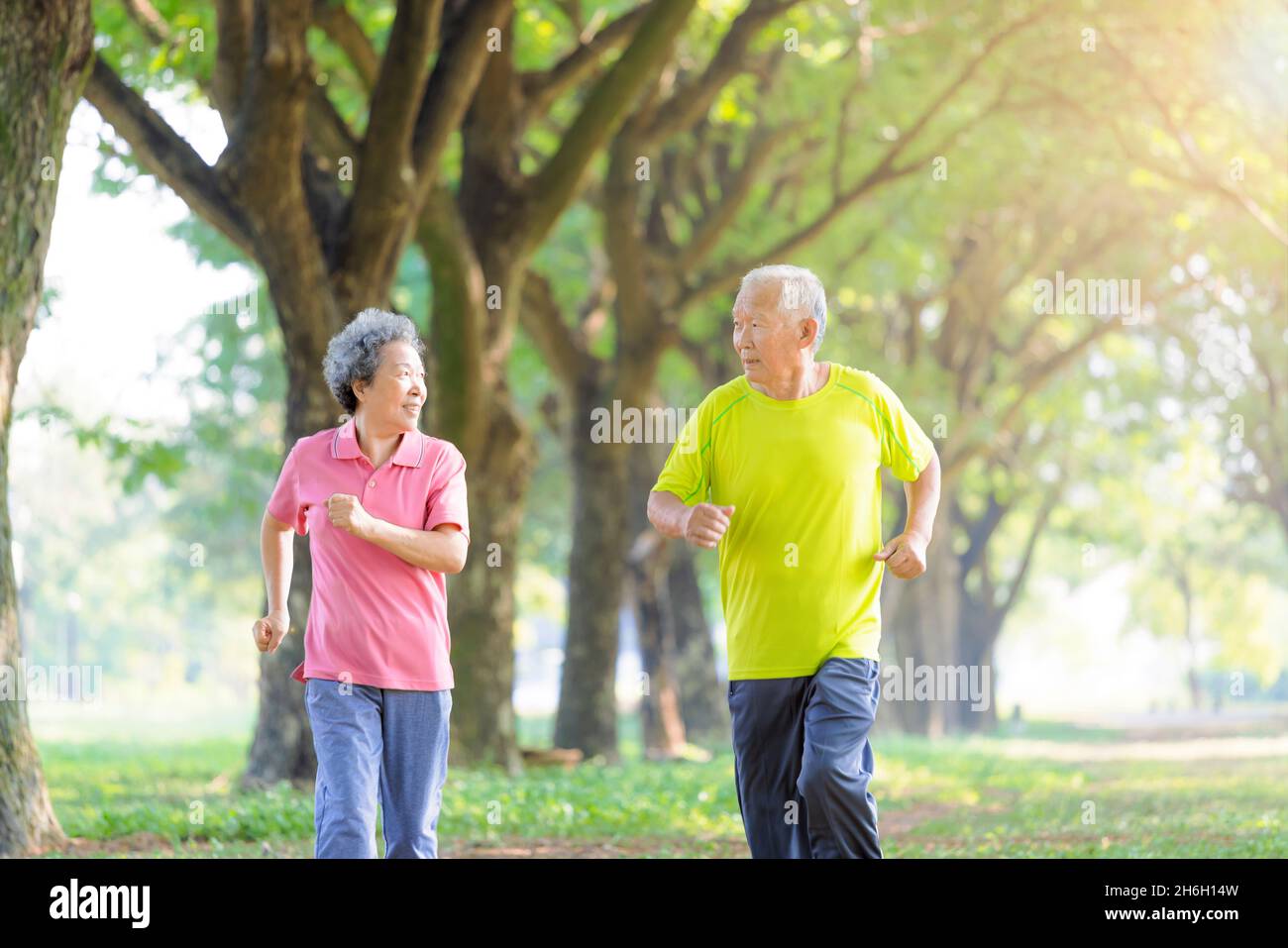 Asiatisches Seniorenpaar beim Joggen im Park am Morgen Stockfoto