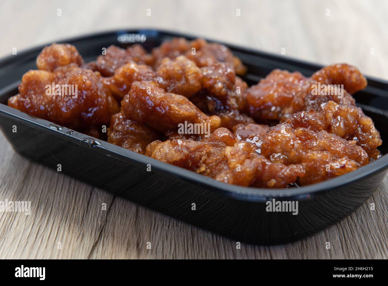 Schüssel mit knusprig panierten Orangenhähnchen in einer würzigen Sauce für große chinesische Fast Frood erstickt. Stockfoto