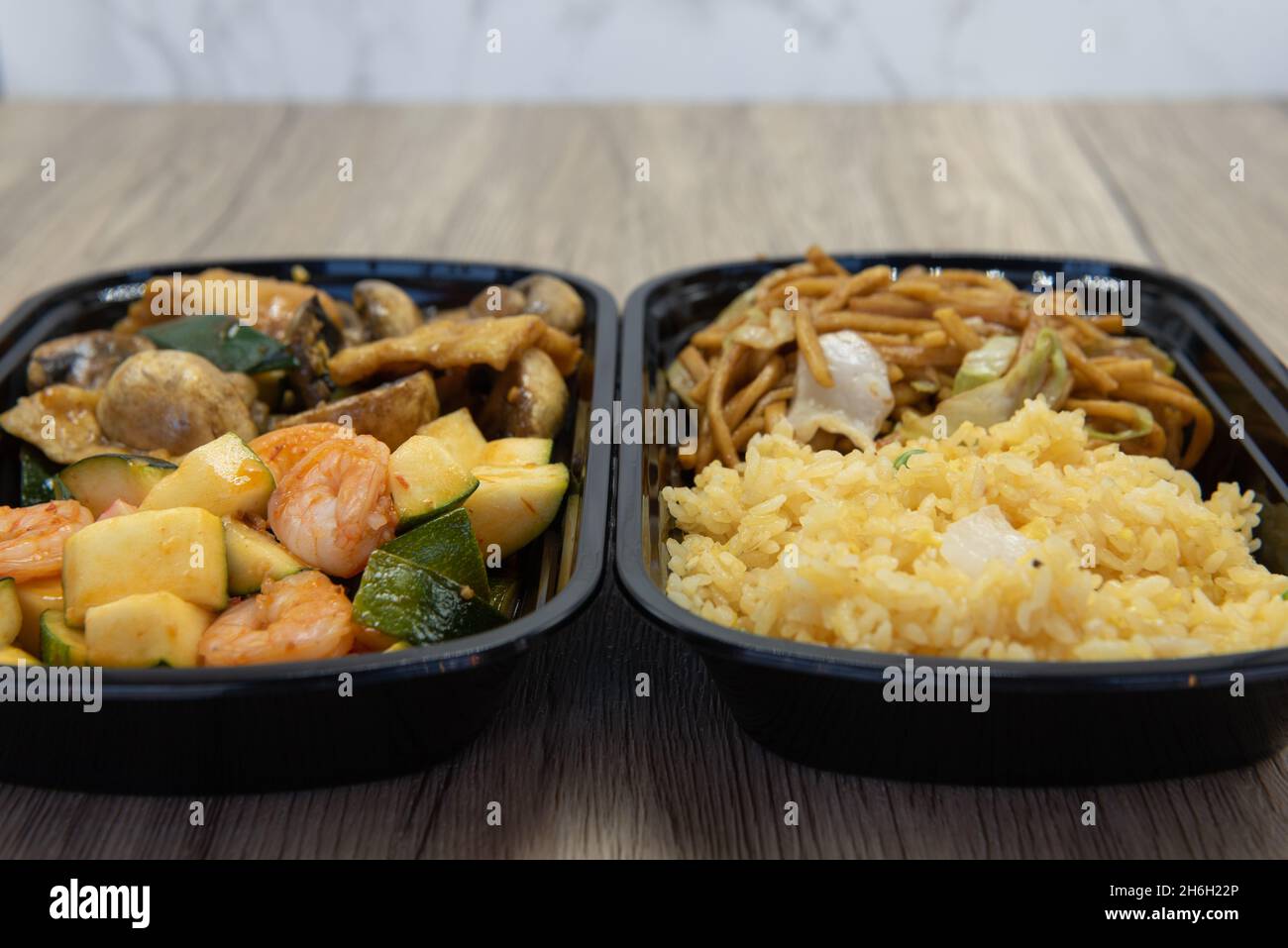 Chinesisches Schnellimbiss mit gebratenem Reis, Chow mein, Zucchini, Shrimps und Pilzen unter Rühren für eine sehr herzhafte Mahlzeit. Stockfoto