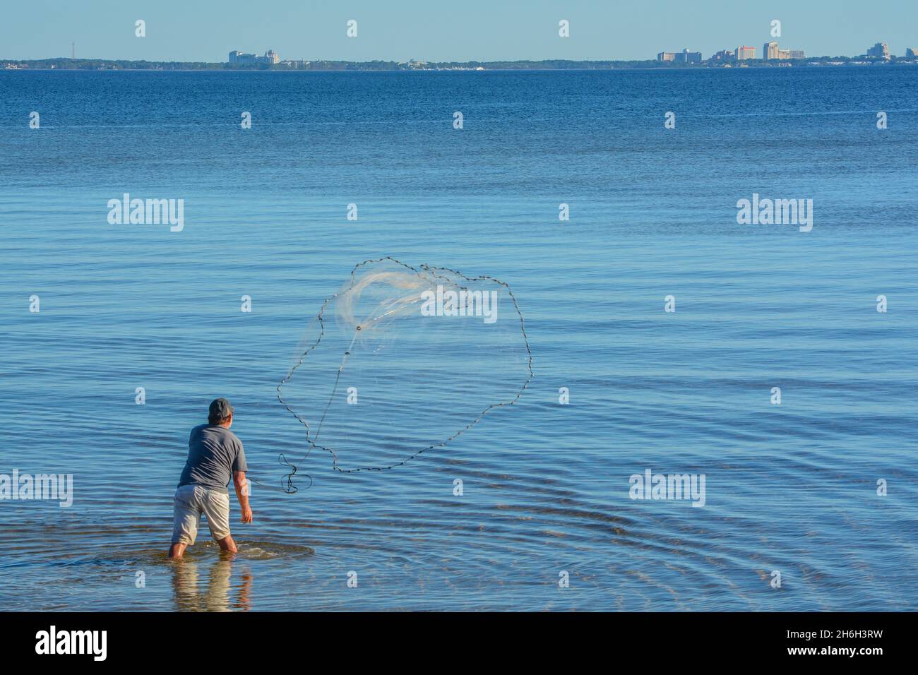 Ein Fischer wirft sein Wurfnetz, um Köderfische zu holen. An der Hammock Bay in Freeport, Walton County, Florida Stockfoto