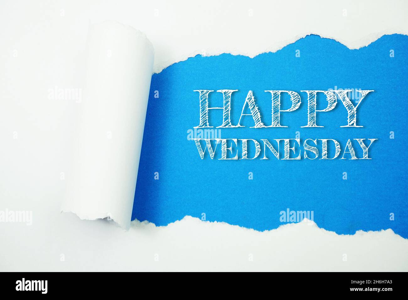 Happy Wednesday Wort auf blauem Hintergrund mit Papier zerrissen Stockfoto
