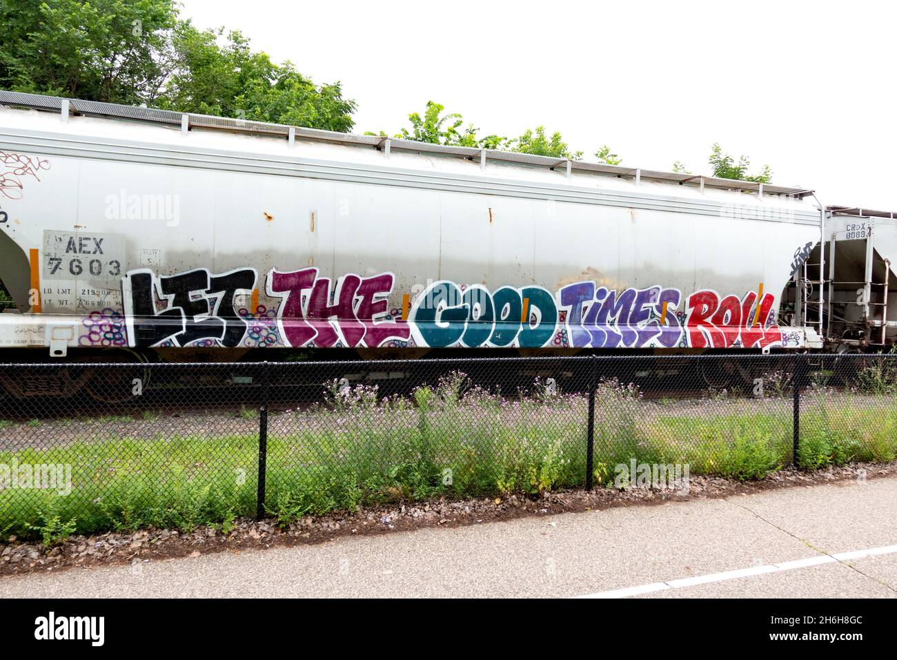 Minnesota Commercial Railroad Transportwagen neben dem Midtown Greenway Trail mit Graffiti „Let the Good Times Roll“. Minneapolis Minnesota, USA Stockfoto