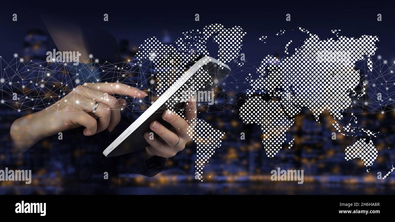 Globales Netzwerk vor dunklem Hintergrund. Hand Touch weißes Tablet mit digitalen Hologramm Welt, Erde, Karte, Globus Zeichen auf Stadt dunkel verschwommen Hintergrund. Stockfoto