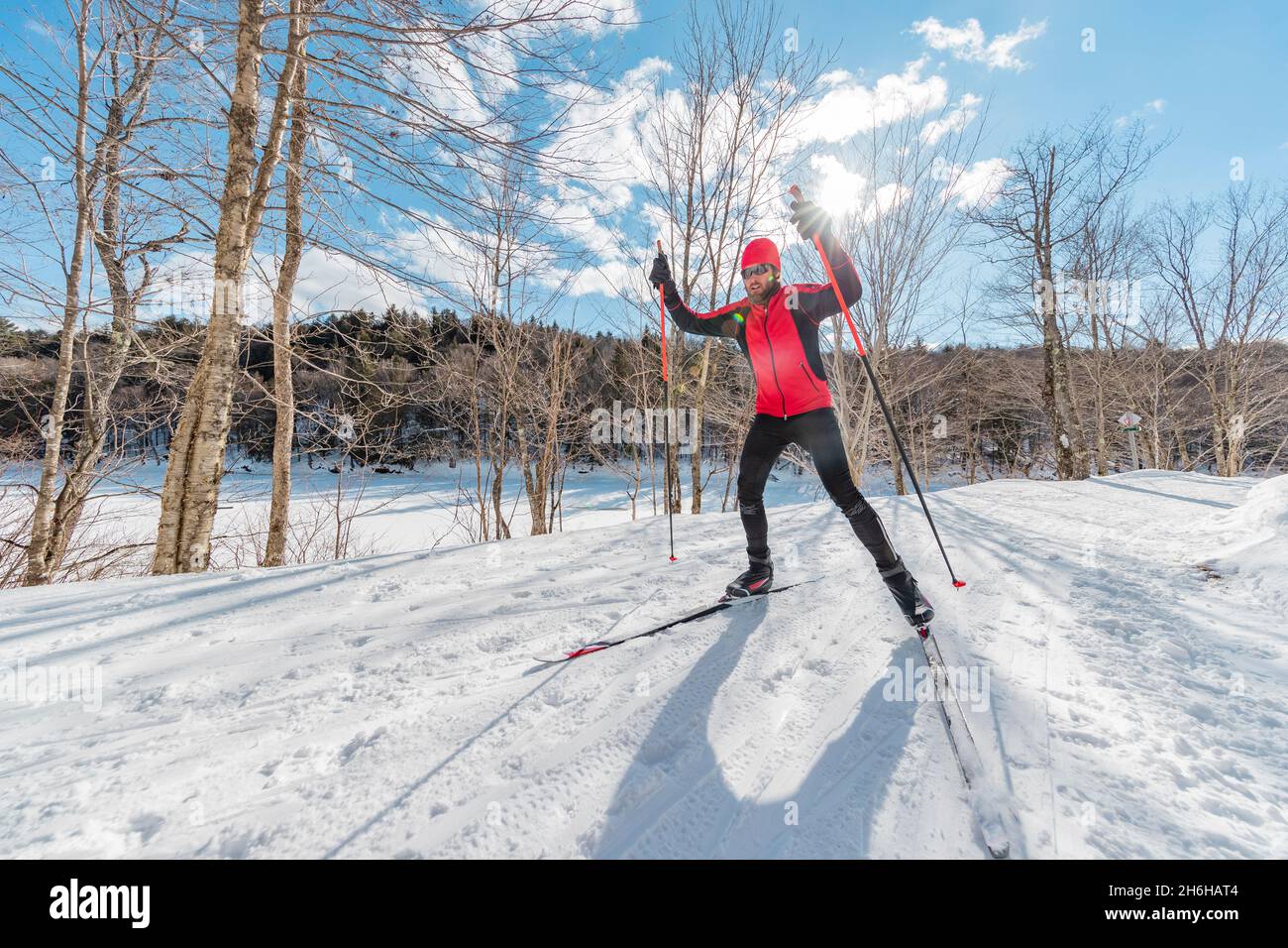 Man Cross Country Skate Skiing Style - Nordic Ski im Wald. Mann im Winter macht Spaß Ausdauer Wintersport im Schnee auf Langlaufski Stockfoto