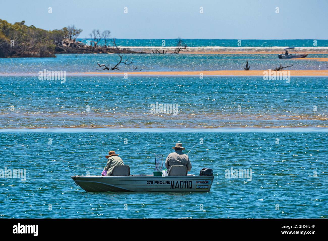Zwei Personen, die von einem Boot aus in Miara, Queensland, QLD, Australien angeln Stockfoto