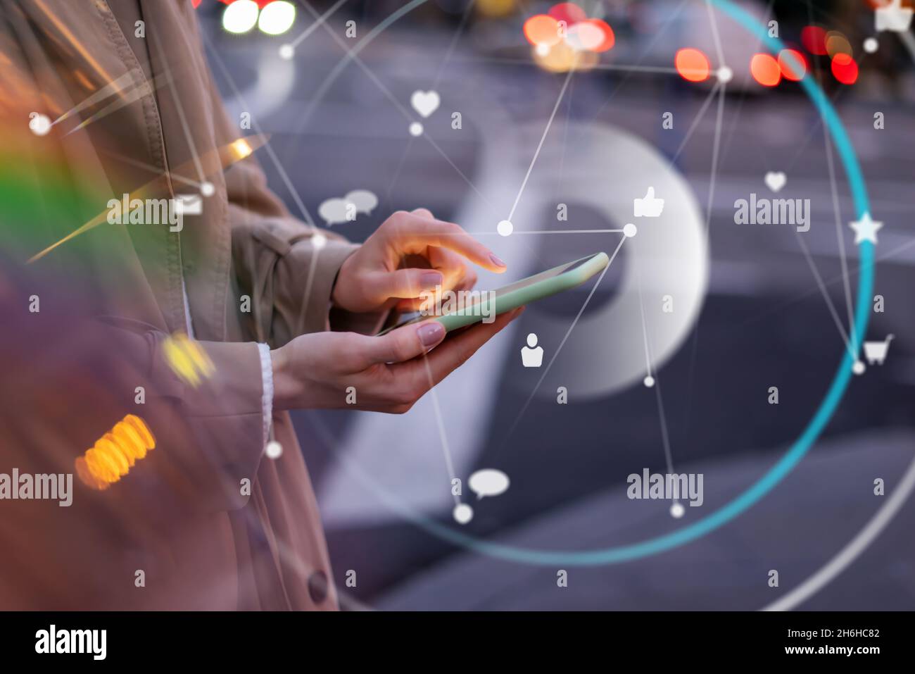 Nahaufnahme der weiblichen Hände mit dem Smartphone. Abendstraße im Hintergrund. Konzept von Social Media oder Netzwerk Stockfoto