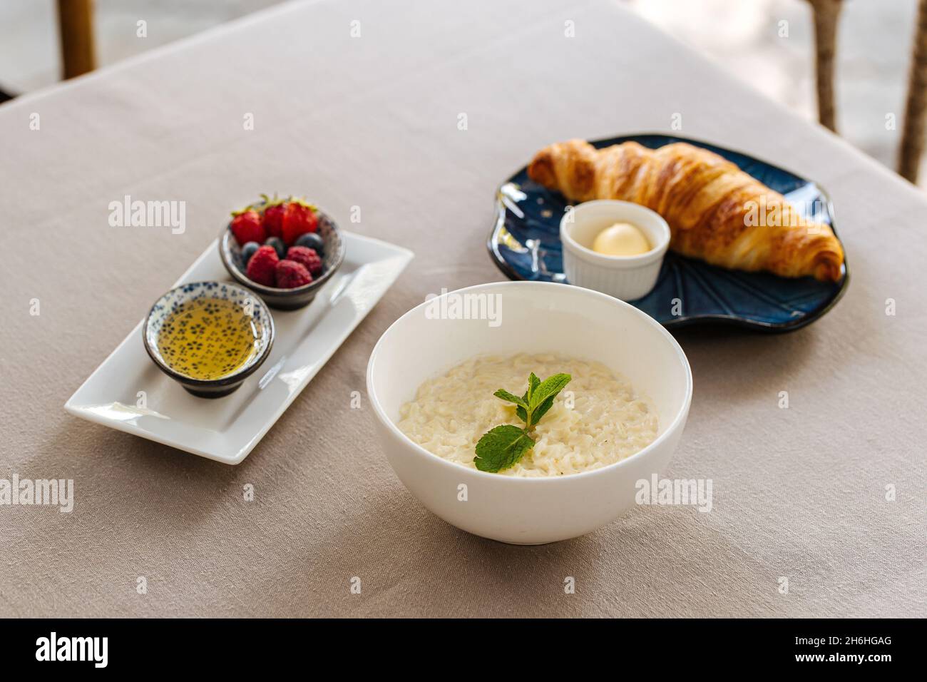 Serviert Frühstück mit Haferbrei und Croissant Stockfoto