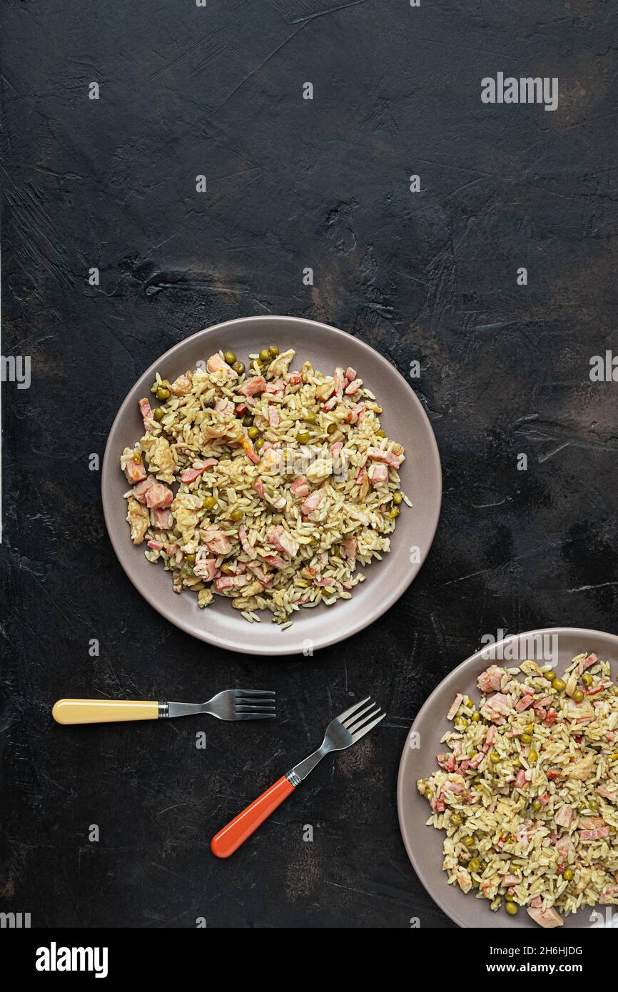 Zwei Teller mit traditionellem kantonesischen oder chinesischen gebratenem Reis auf einem dunklen Tisch, Draufsicht Stockfoto
