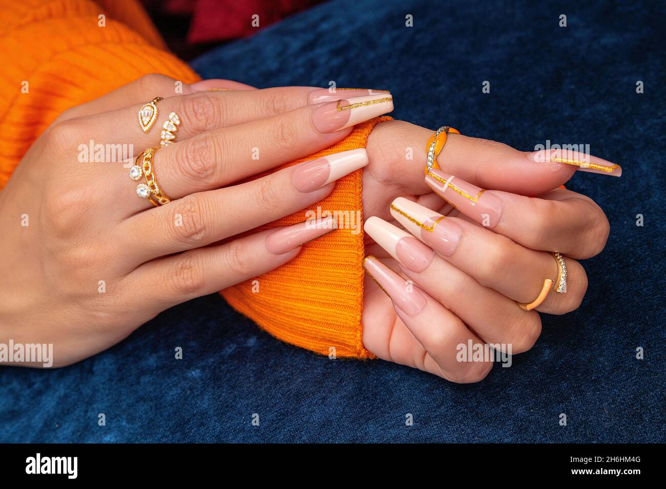 Schöne gepflegte Frauenhände mit weißen Nägeln und Diamantringen in der Hand. Nagellack in weißer Farbe. Maniküre, Pediküre Schönheitssalon Mode Co Stockfoto