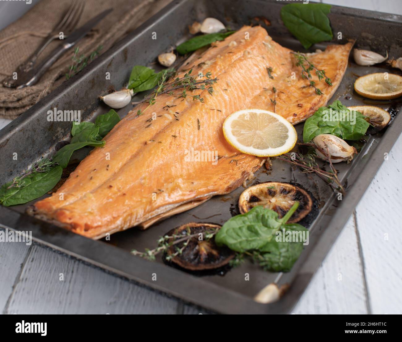 Gebratener halber Lachs mit Kräutern, Olivenöl und Zitrone Stockfoto