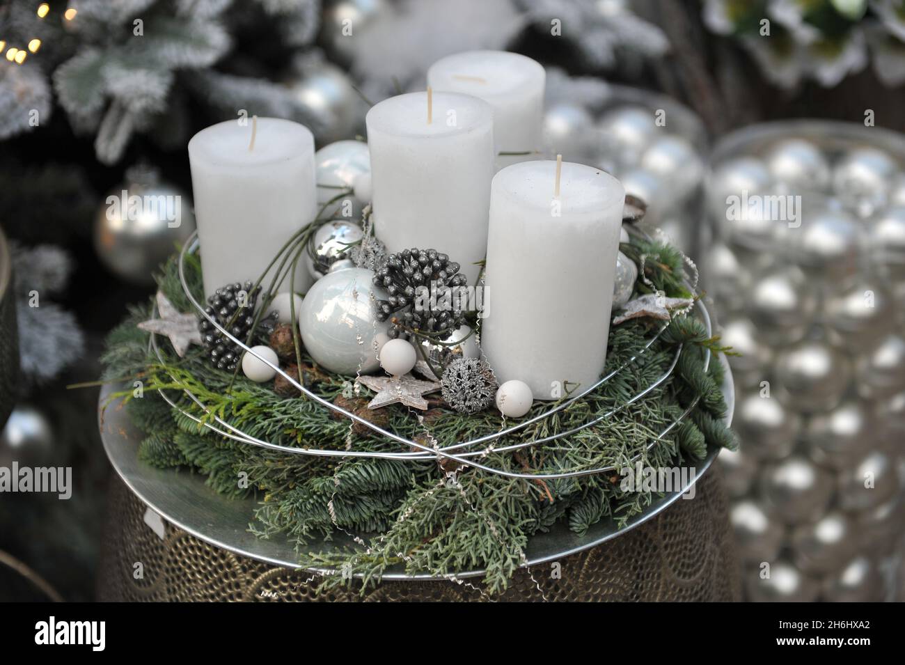 Weiße Adventskerzen in einer Holzkiste mit weihnachtlicher Dekoration und Platz für Text Stockfotografie