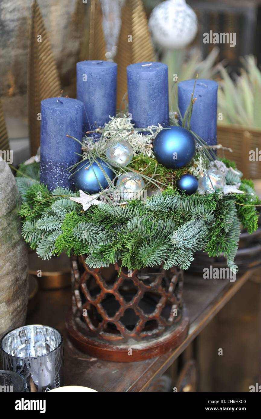 Weihnachtliche Dekoration im Innenraum. Ein Adventskranz mit vier blauen Kerzen Stockfoto