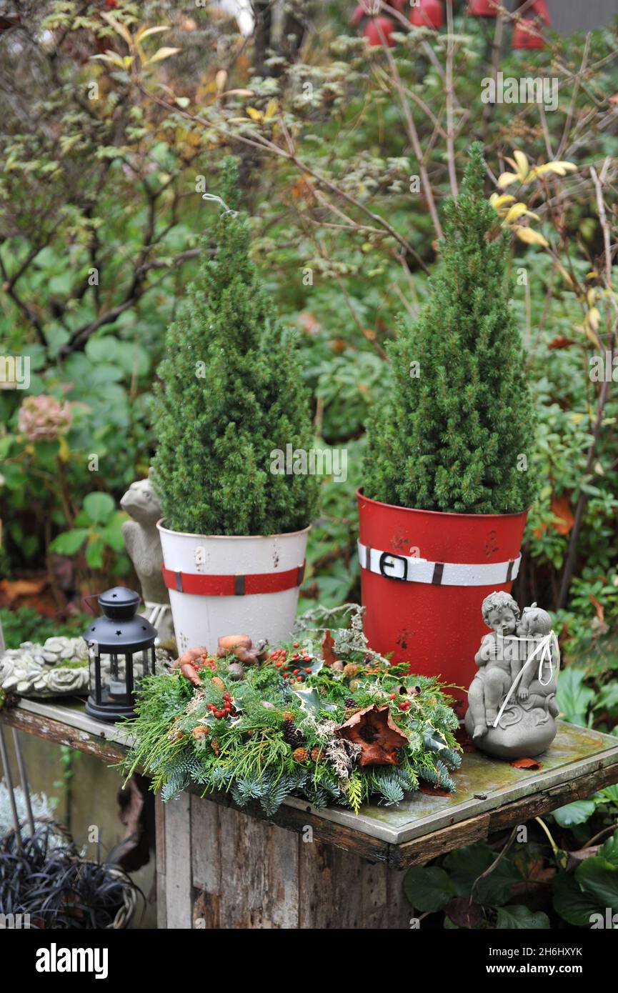 Weihnachtsdekoration im Garten. Weihnachtskranz aus falscher Zypresse und Tanne auf einem Holztisch Stockfoto