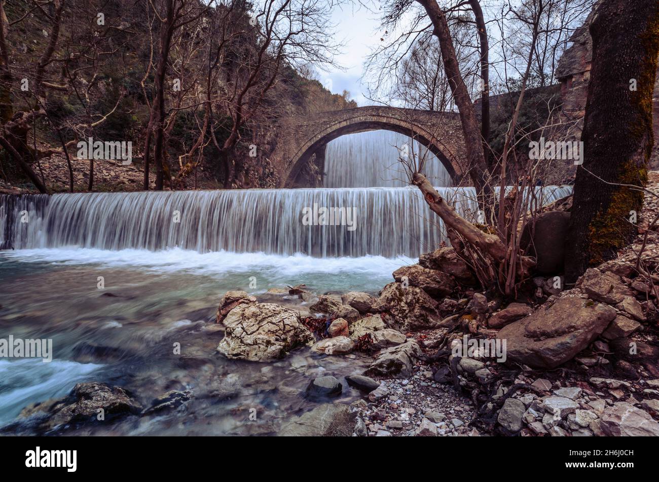 Historische Steinbrücke von Palaiokarya mit seinen zwei künstlichen Wasserfällen in der Nähe von Trikala und Meteora. Stockfoto