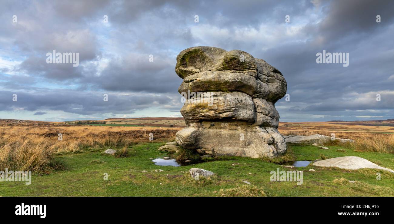Der große Felsbrocken, bekannt als Eagle Stone, liegt auf einer Moorlandschaft in der Nähe von Baslow Edge im Peak District National Park, Derbyshire, England. Stockfoto