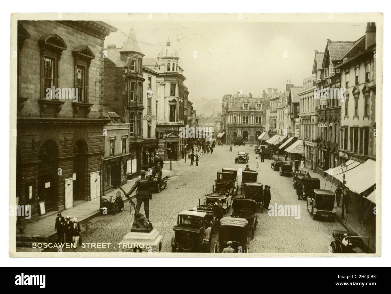 Originalpostkarte aus den frühen 1920er Jahren von Boscawen Street Truro, Cornwall, mit Gedenkstätte zum 1. Weltkrieg, Geschäften, dem Red Lion Hotel (das abgerissen wurde, nachdem ein Lastwagen es getroffen hatte) Autos. Fotografiert von den Opie Studios aus der Coinage Hall. Stockfoto