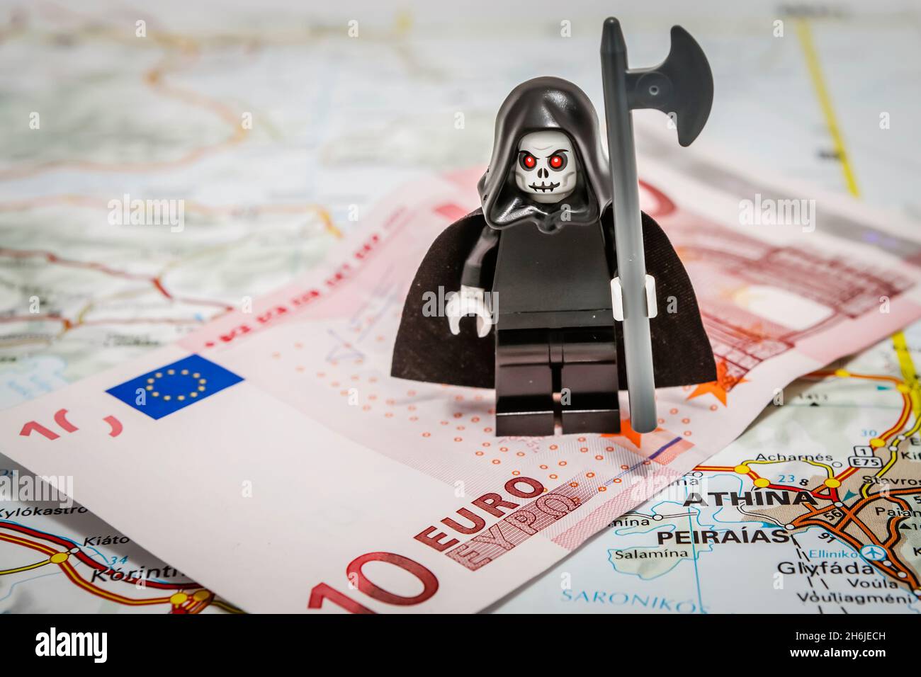 Der Tod des Euro - der grimmige Schnitter, der auf einer 10-Euro-Note auf einer Europakarte steht Stockfoto