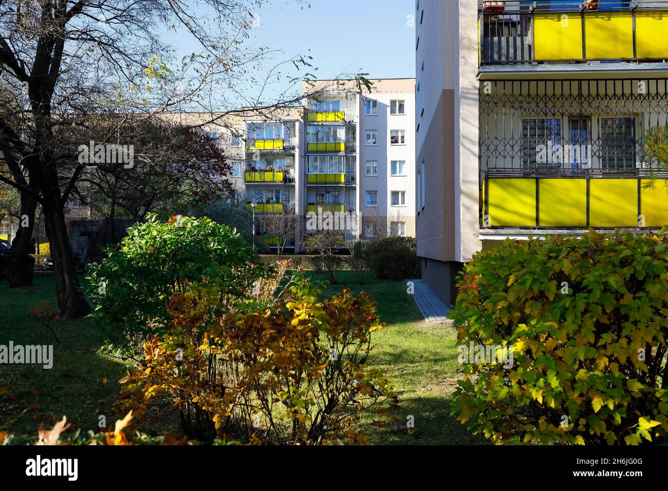 Warschau, Polen - 1. November 2021: Auf weitläufigen Rasenflächen wachsen unter Sträuchern und Bäumen Wohngebäude mit Balkonen, die hier zu sehen sind Stockfoto