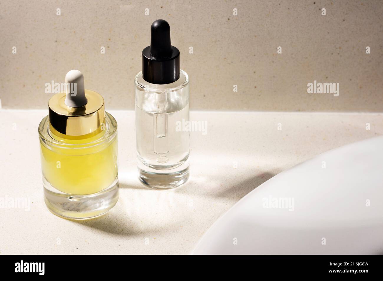 Glasgläser mit Serum und Kosmetiksäure im Badezimmer Stockfoto