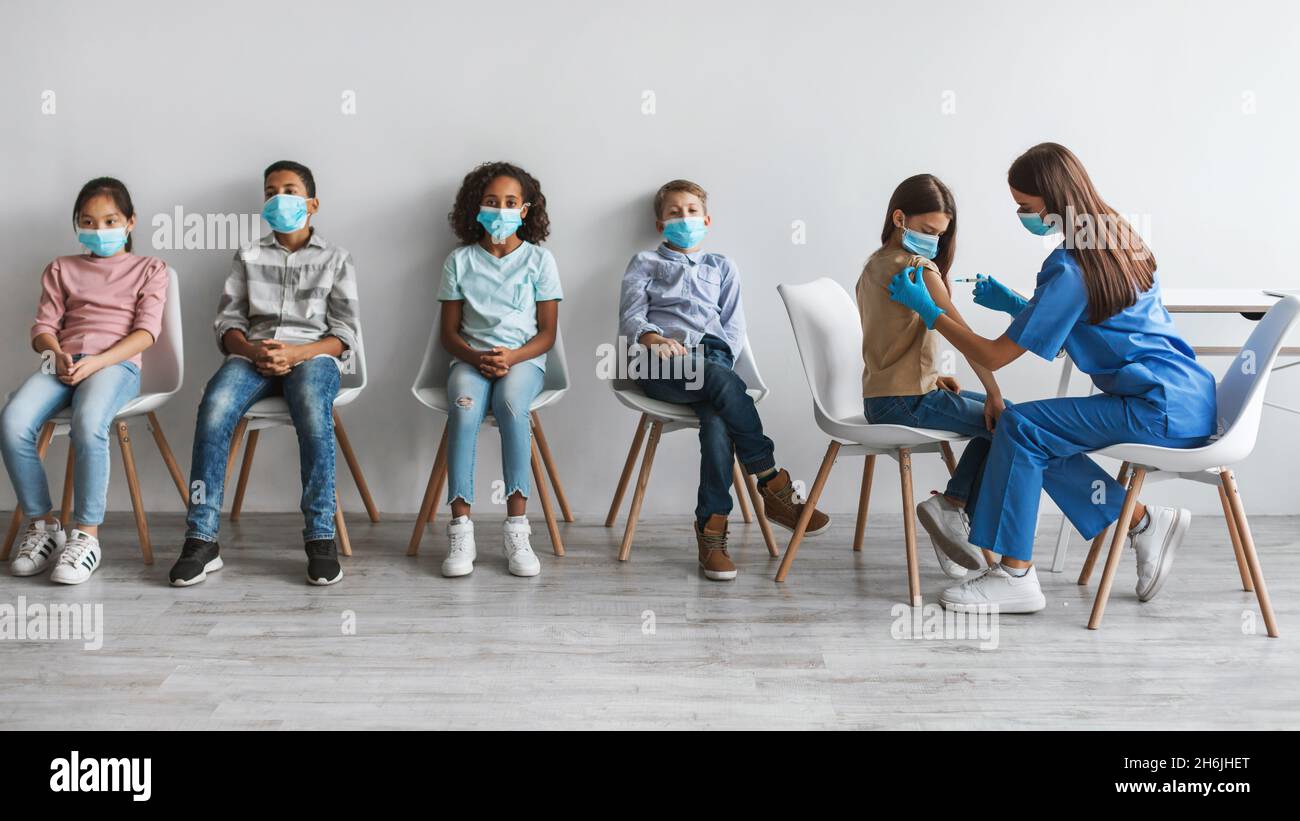 Medizinische Mitarbeiterin Frau Impfen Verschiedene Gruppe Von Kindern In Der Klinik Stockfoto