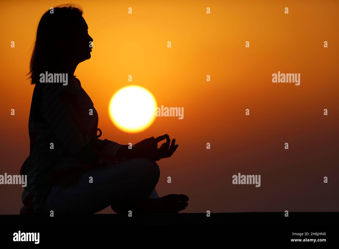 Frau, die Yoga-Pose und Meditation bei Sonnenuntergang als Konzept für Ruhe und Entspannung praktiziert, Vereinigte Arabische Emirate, Mittlerer Osten Stockfoto