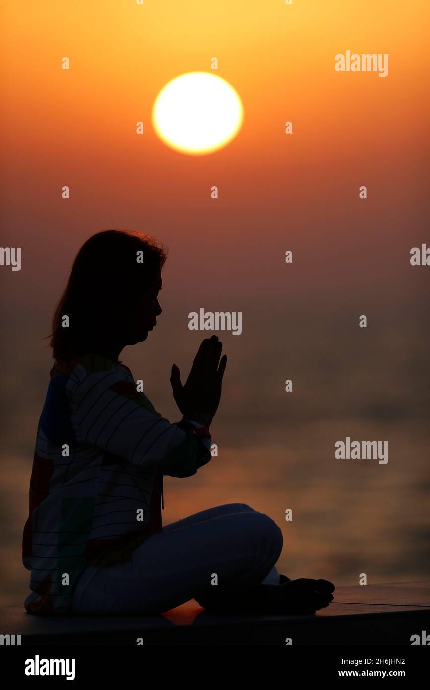 Frau, die Yoga-Pose und Meditation bei Sonnenuntergang als Konzept für Ruhe und Entspannung praktiziert, Vereinigte Arabische Emirate, Mittlerer Osten Stockfoto