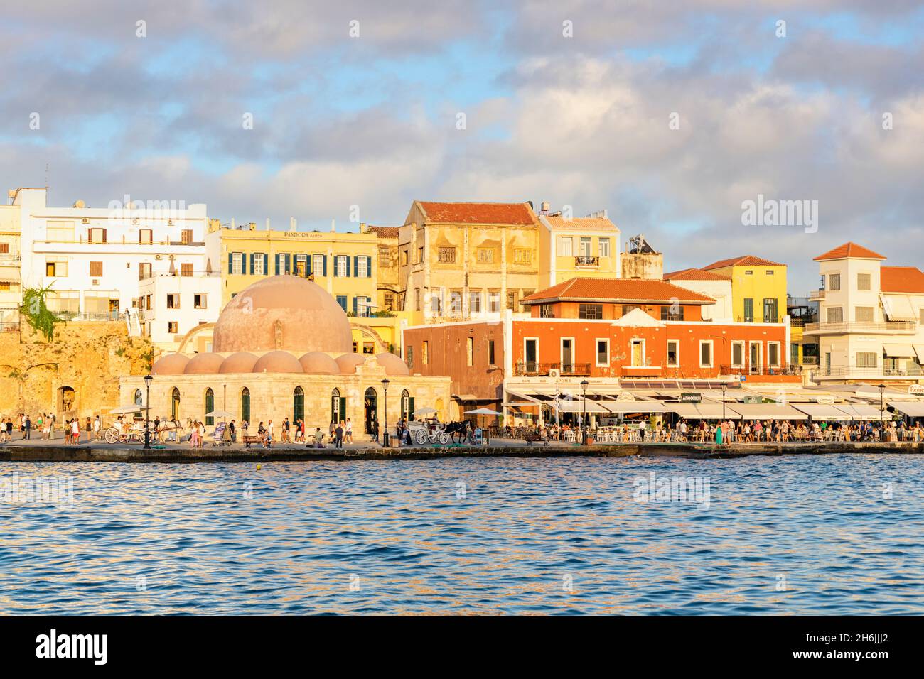 Touristen genießen den Sonnenuntergang im alten venezianischen Hafen von Chania, Kreta, griechische Inseln, Griechenland, Europa Stockfoto