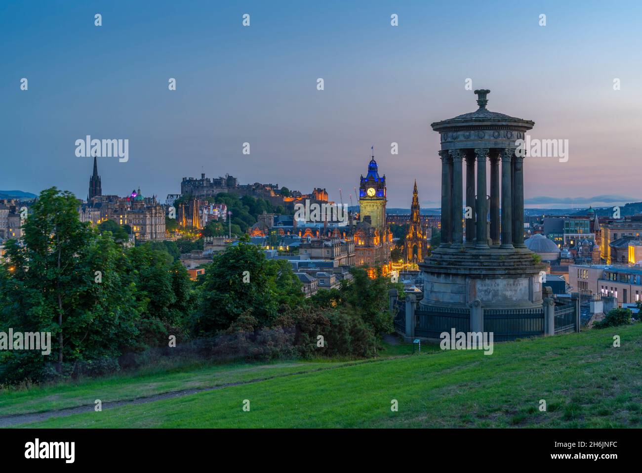 Blick auf das Edinburgh Castle, das Balmoral Hotel und das Dugald Stewart Monument vom Calton Hill in der Abenddämmerung, USA, Edinburgh, Lothian, Schottland Stockfoto