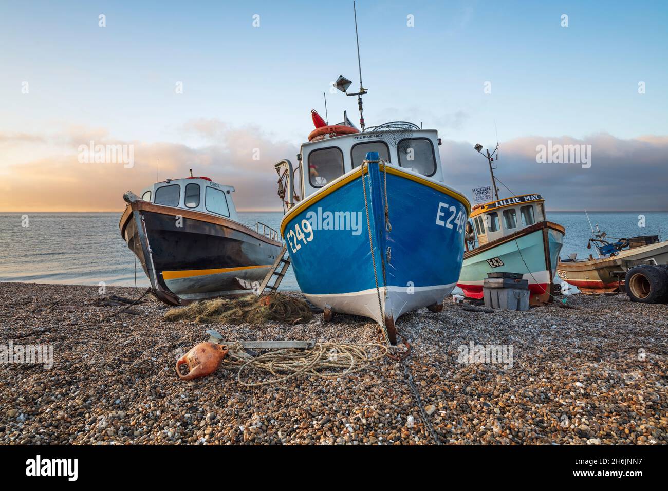 Fischerboote, die bei Sonnenaufgang, Bier, Jurassic Coast, Devon, England, am Kiesstrand hochgezogen wurden, Vereinigtes Königreich, Europa Stockfoto