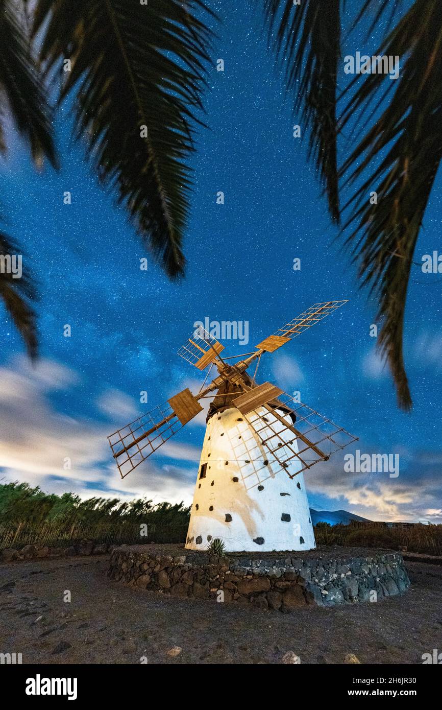 Palmen umrahmt eine einone Windmühle unter der Milchstraße, El Cotillo, La Oliva, Fuerteventura, Kanarische Inseln, Spanien, Atlantik, Europa Stockfoto