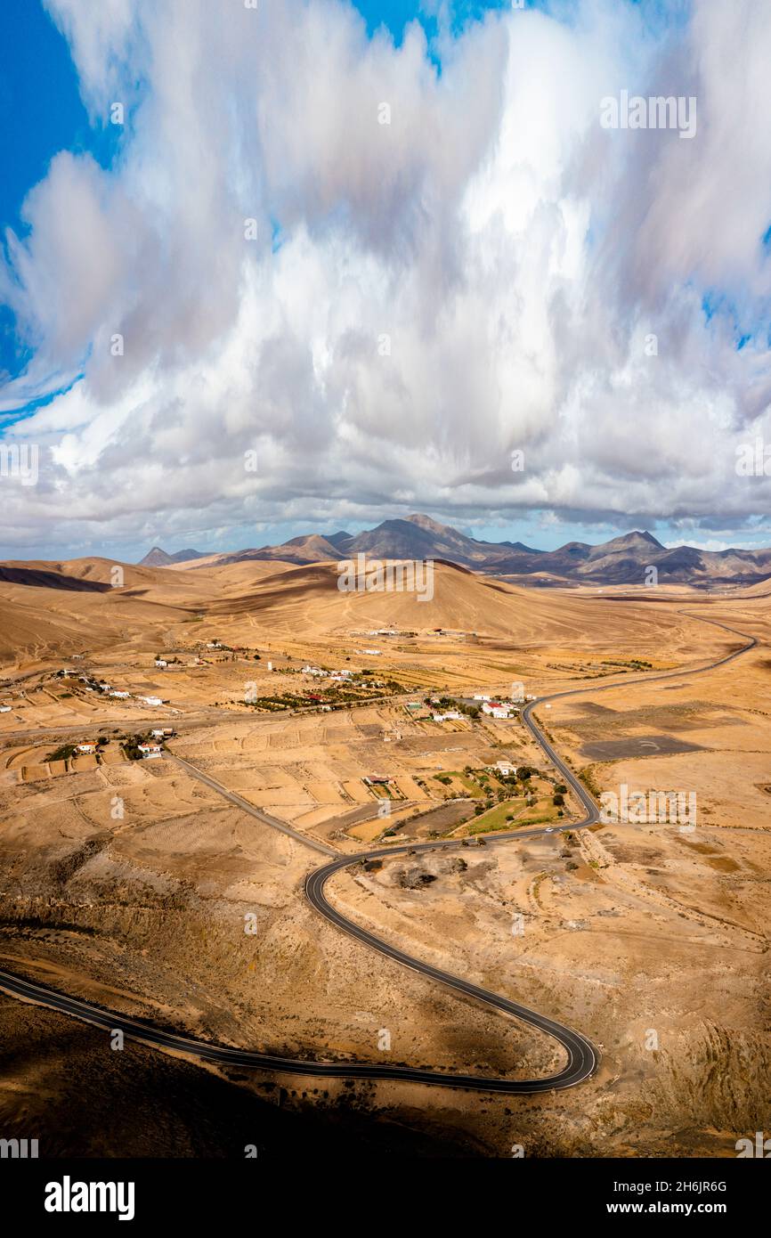 Malerische Wolken auf kurvenreicher Straße durch Wüstenberge, Luftbild, Tefia, Fuerteventura, Kanarische Inseln, Spanien, Atlantik, Europa Stockfoto