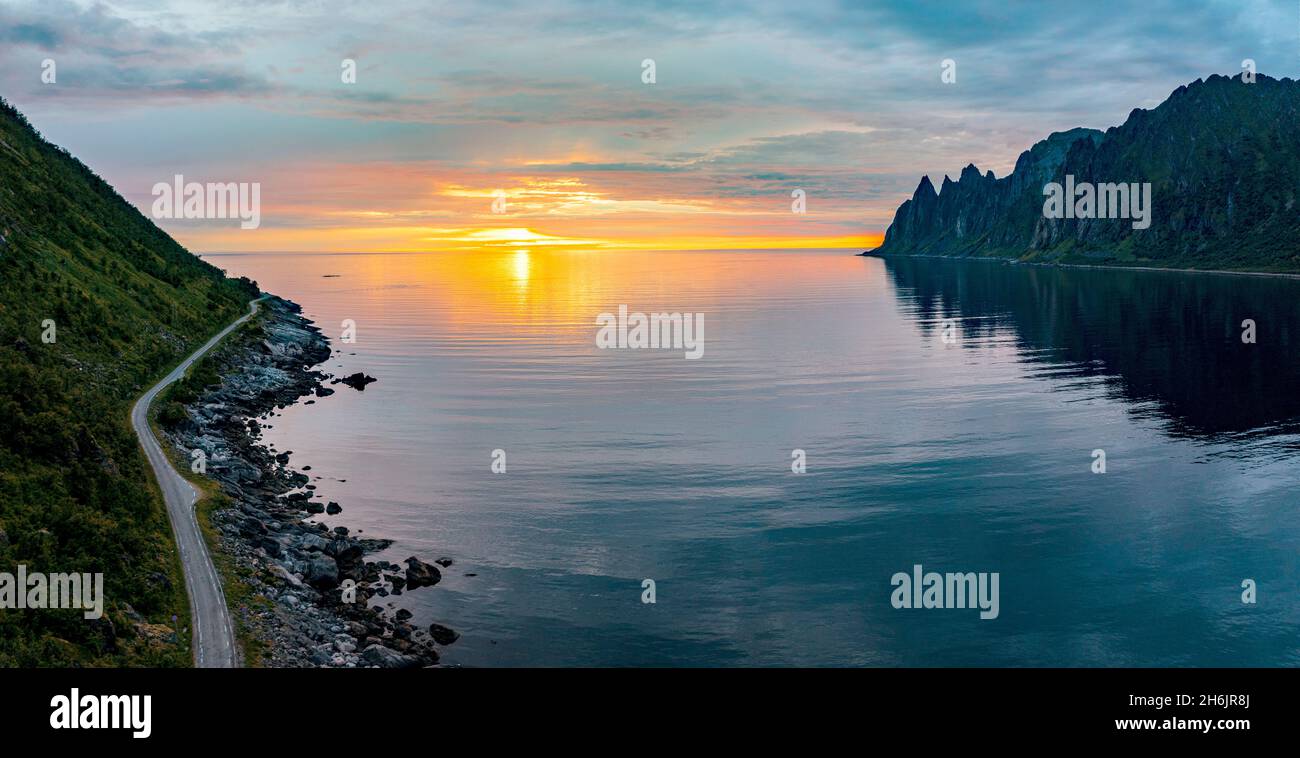 Leere Asphaltstraße am Rand des arktischen Meeres, von der Mitternachtssonne getroffen, Ersfjord, Senja, Troms County, Norwegen, Skandinavien, Europa Stockfoto