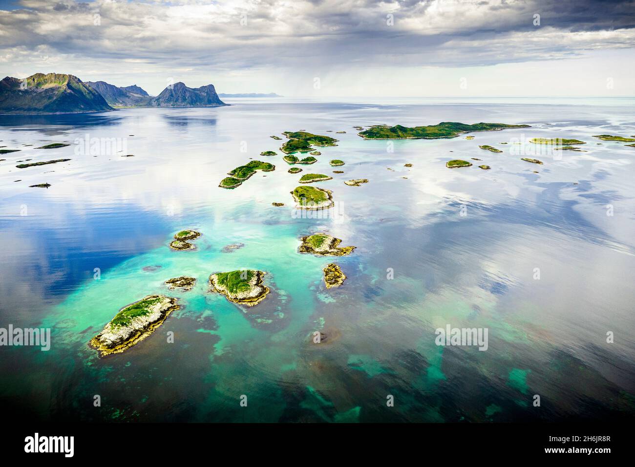 Wolkiger Himmel über den Bergsoyan Inseln im klaren Wasser des Fjords, Hamn i Senja, Skaland, Senja, Troms County, Norwegen, Skandinavien, Europa Stockfoto