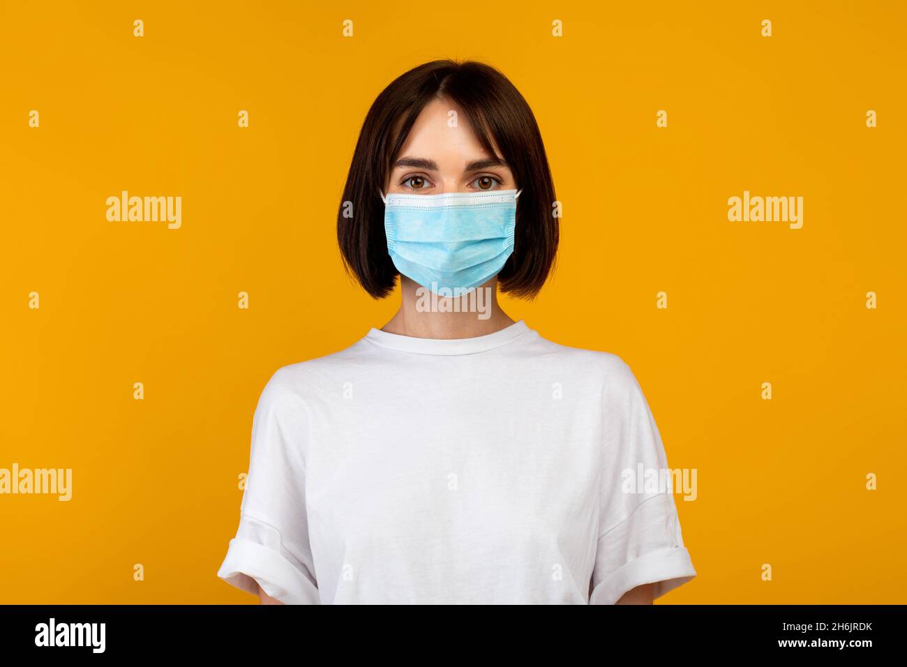 Virenschutzkonzept. Porträt einer Dame mit medizinischer Maske isoliert auf pastellorangenen Studio-Hintergrund, Banner Stockfoto