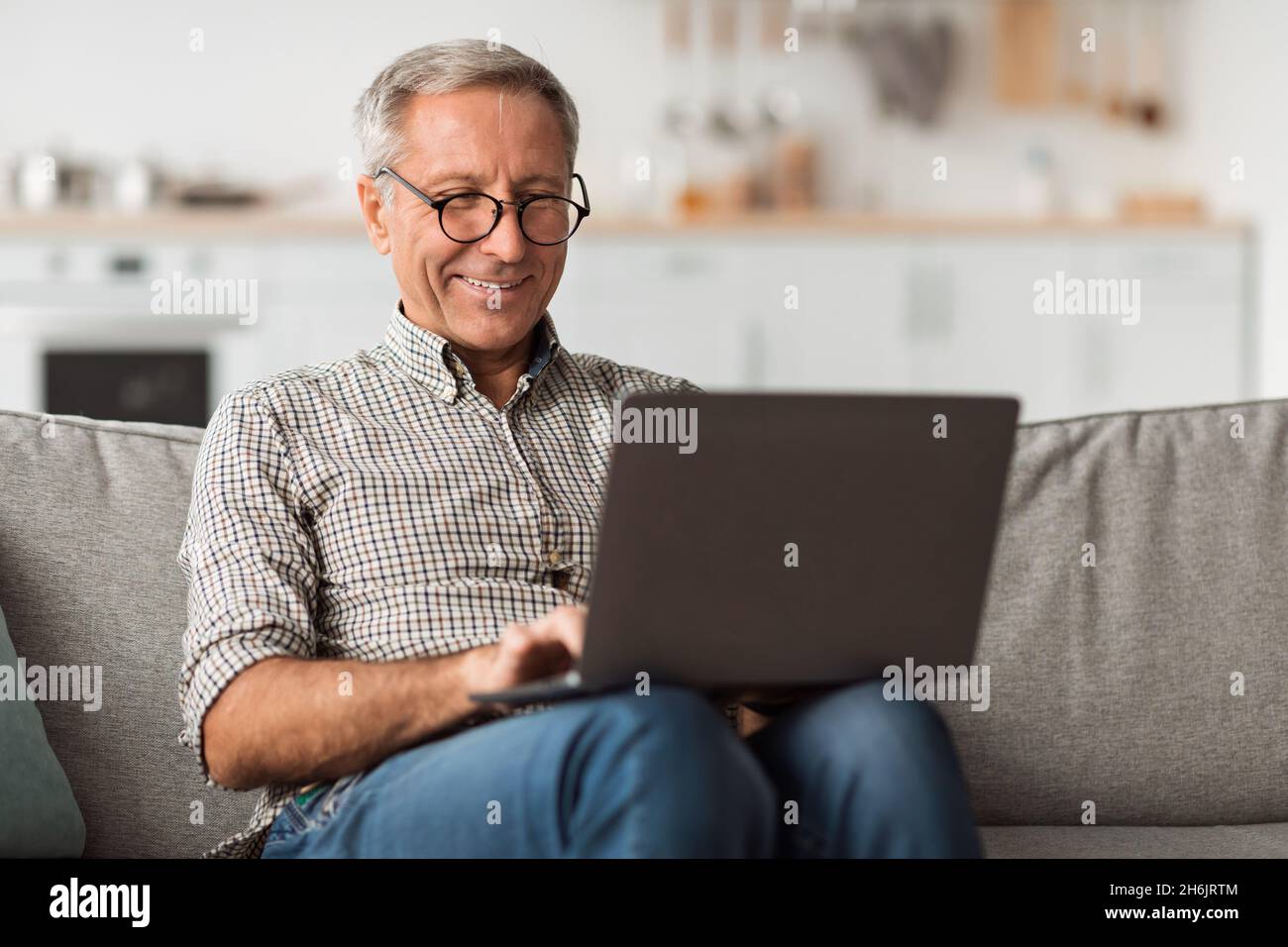 Glücklicher Älterer Mann Mit Laptop Surfen Im Internet Sitzen Zu Hause Stockfoto