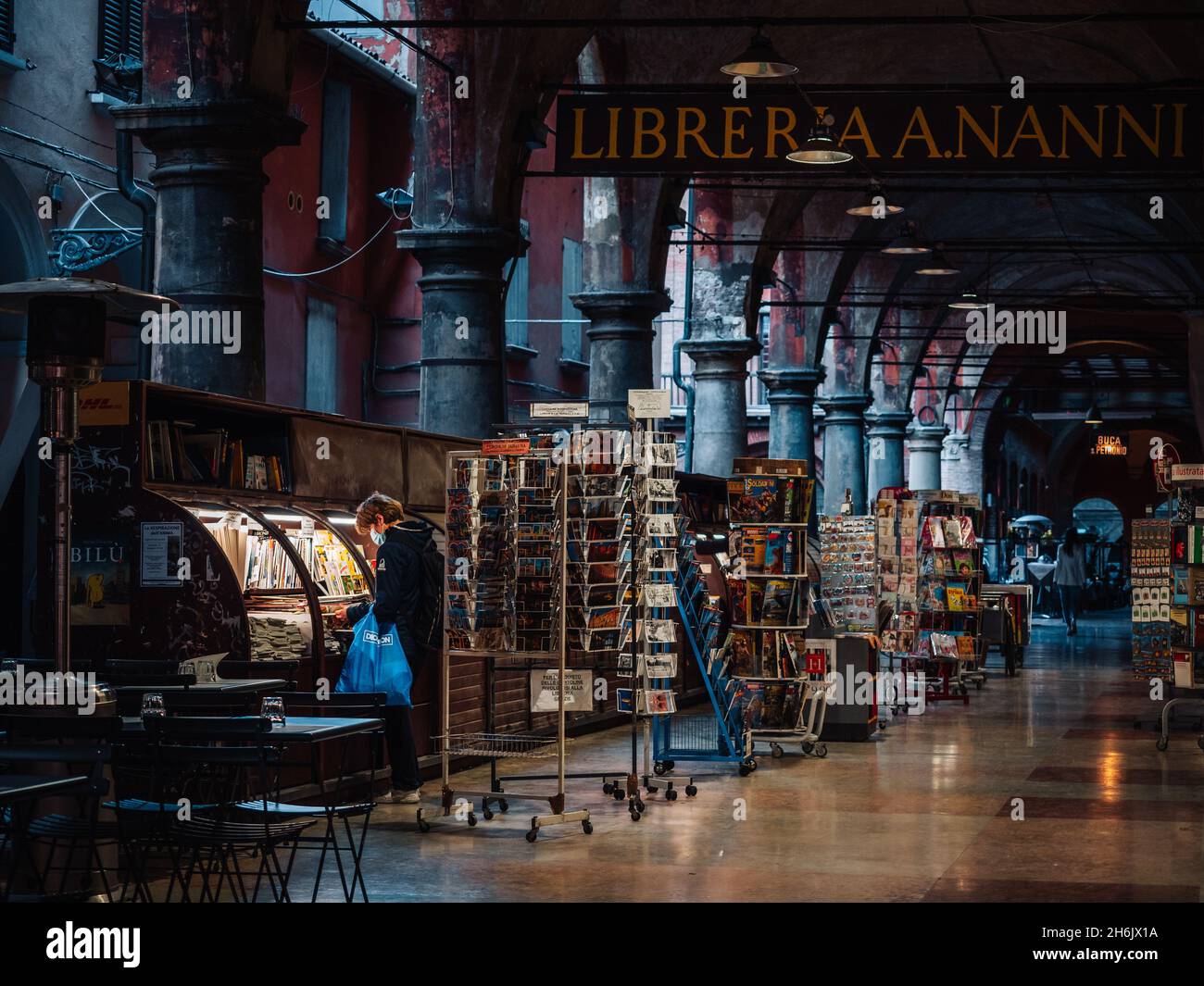 Via De' Musei in der Altstadt von Bologna mit einer Person, die Bücher in einer Buchhandlung ansieht, Bologna, Emilia Romagna, Italien, Europa Stockfoto