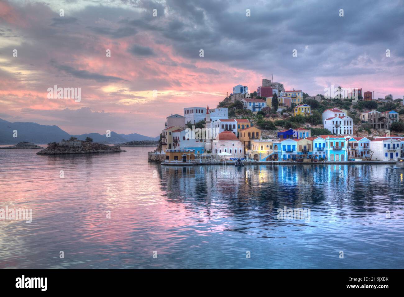 Sonnenaufgang, Gebäude am Hafeneingang, Kastellorizo (Megisti) Island, Dodecanese Group, Greek Islands, Greece, Europa Stockfoto