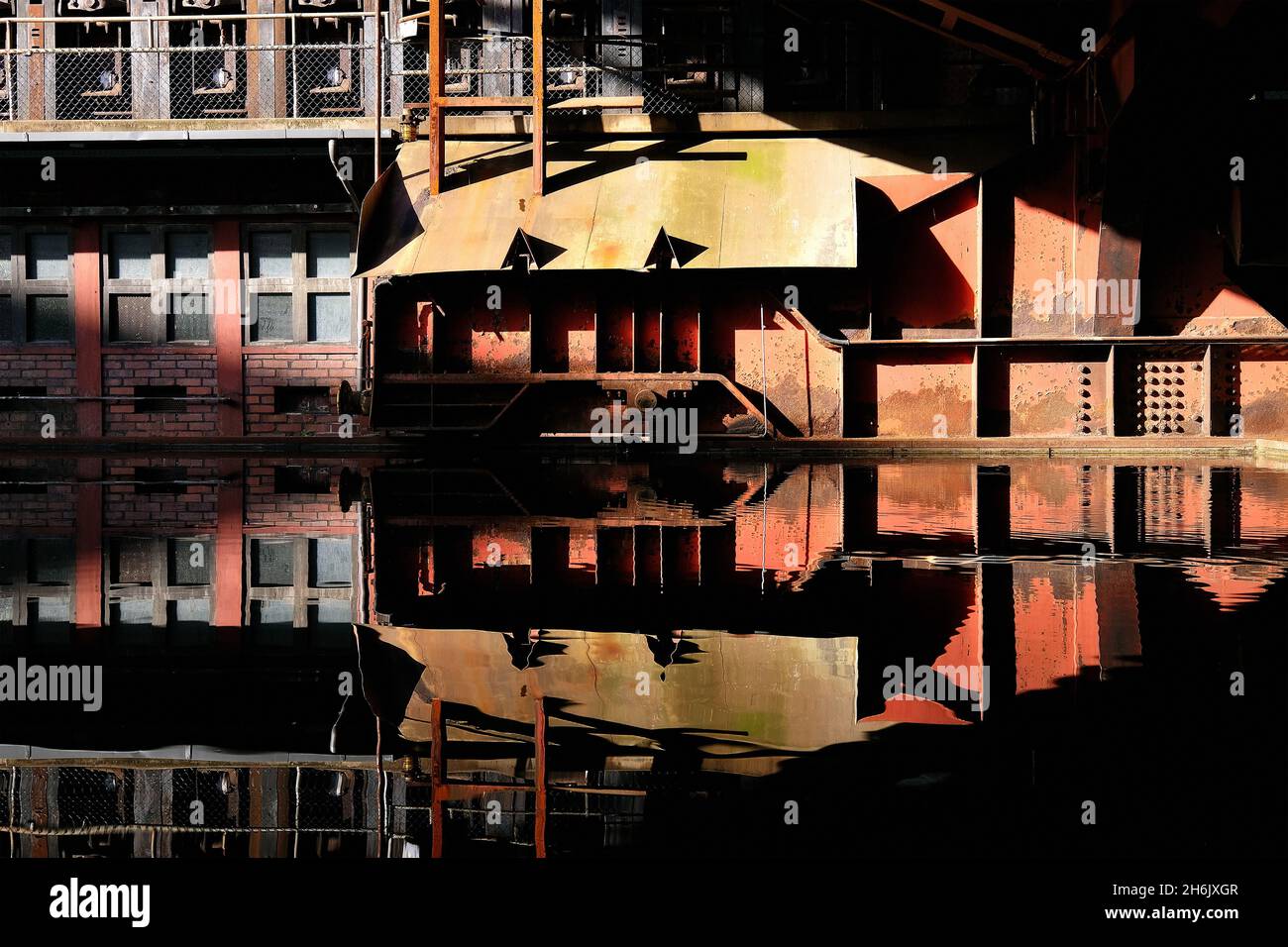 Deutschland, NRW, Essen, Zeche Zollverein; Reflexionen in der Wasseroberfläche neben der Kokerei. Stockfoto