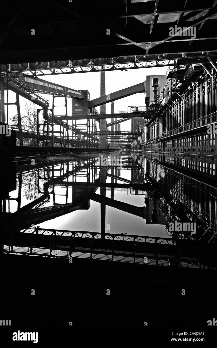 Deutschland, NRW, Essen, Zeche Zollverein; Reflexionen in der Wasseroberfläche neben der Kokerei. Stockfoto