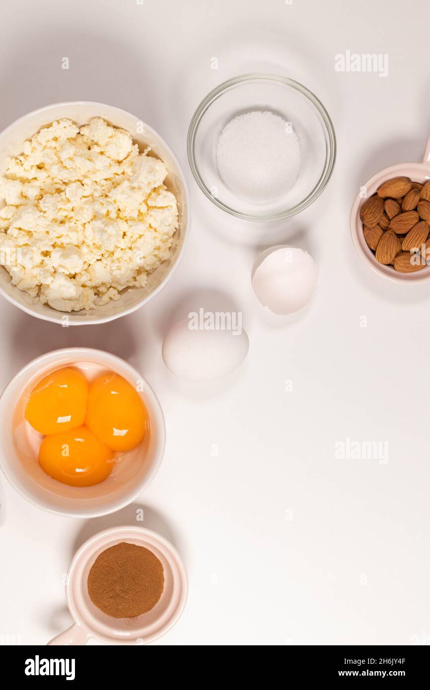 Backzutaten auf einem weißen Tisch. Weiße Eier, Mehl, Zucker und Gewürze. Home Konzept zum Backen, Backen von Kuchen oder Keksen. Draufsicht. Flach Stockfoto