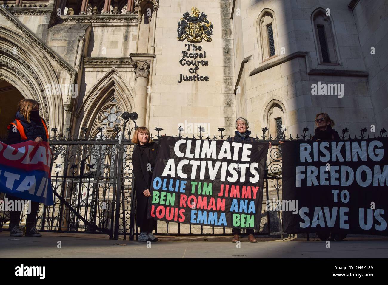 London, Großbritannien. November 2021. Demonstranten halten ein Banner mit den Namen von vor Gericht stehenden britischen Aktivisten mit den Namen von Beleidigungen vor den königlichen Gerichtshöfen. Neun Aktivisten stehen vor einer Gefängnisstrafe, weil sie während der jüngsten Proteste gegen Großbritannien eine Verfügung gebrochen haben. Kredit: Vuk Valcic / Alamy Live Nachrichten Stockfoto