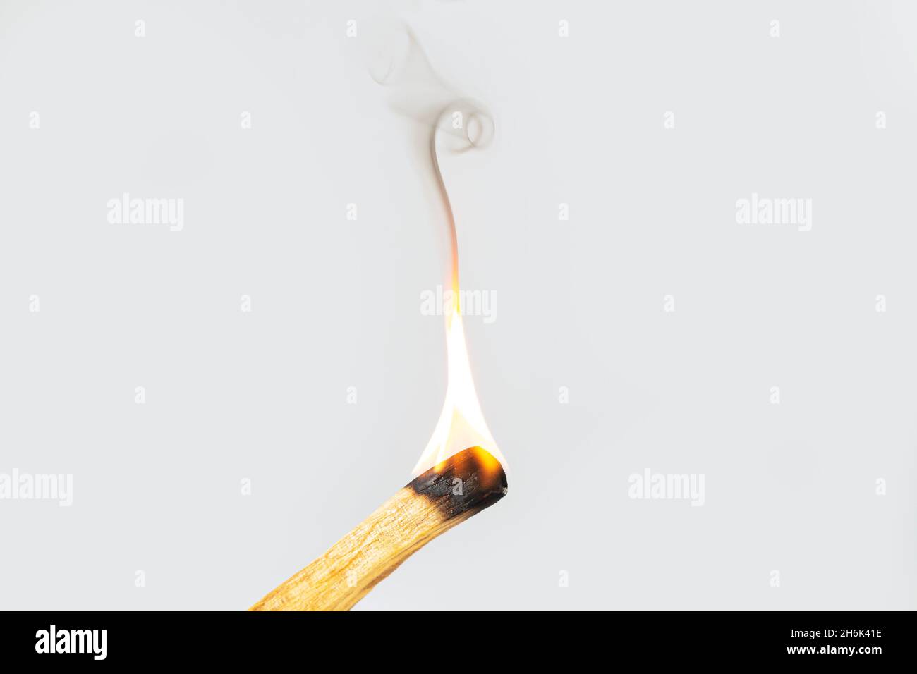 Palo santo oder Räucherstäbchen aus heiligem Holz brennen mit Flamme und aromatischem Rauch. Reinigung negative Energie Konzept Stockfoto