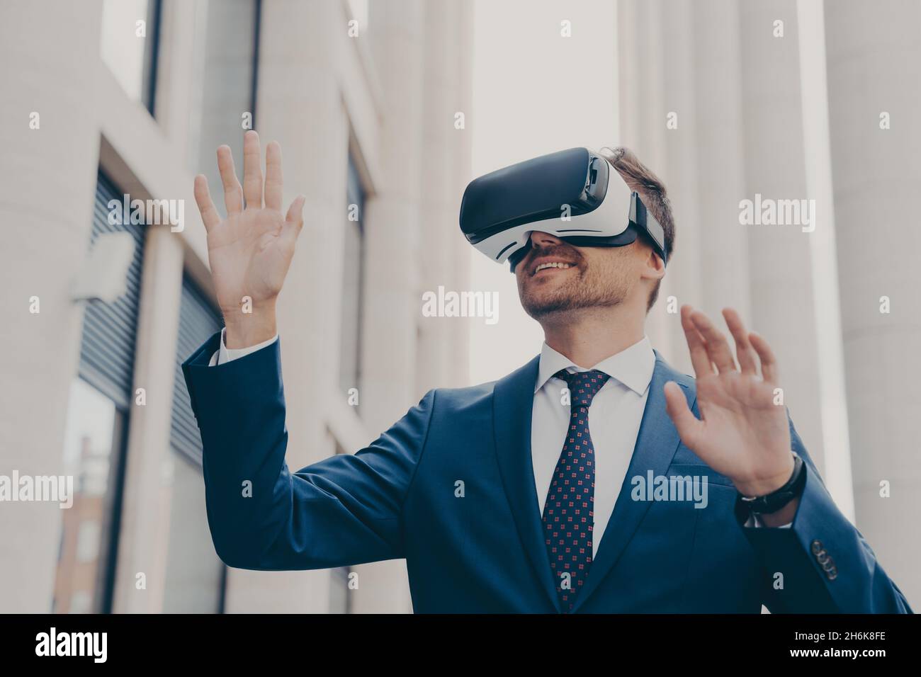 Geschäftsmann in einer Virtual-Reality-Brille mit VR-Brille, während er auf der Stadtstraße im Freien steht Stockfoto