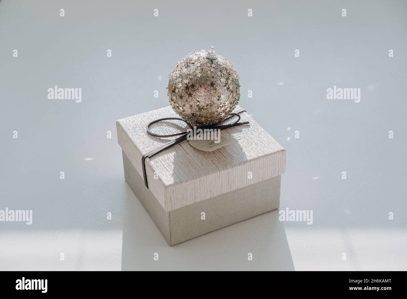 Weihnachten minimal Web-Banner mit Weihnachtsschmuck Ball und Geschenkbox auf hellem Hintergrund. Weihnachten Geschenk-Box und funkelt Weihnachten Ornament Ball auf Stockfoto