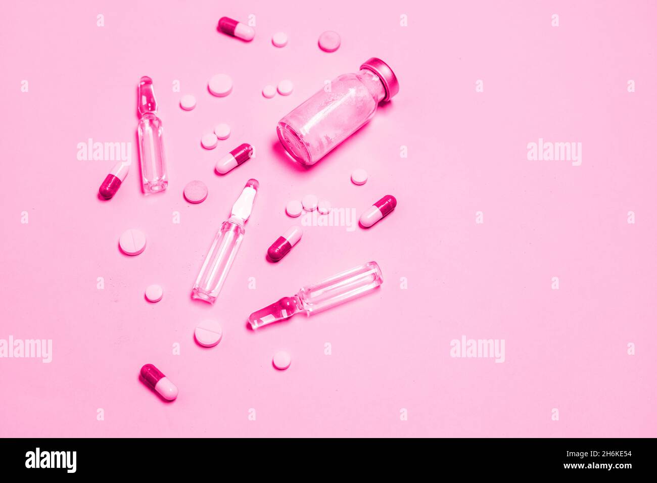 Impfstoff und Spritze, verschiedene pharmazeutische Pillen, Tabletten und Kapseln auf blauem Hintergrund. Gesundheitswesen und medizinisches Konzept. Stockfoto