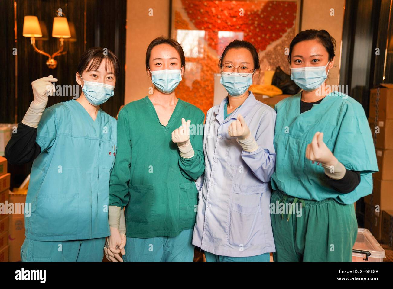 (211116) -- HEIHE, 16. November 2021 (Xinhua) -- Liu Bing (1. L) und ihre Kollegen posieren für Fotos in der Nähe eines Nukleinsäuretestlabors namens Huoyan, oder Fire Eye, in der Stadt Heihe, nordöstlich der Provinz Heilongjiang, 15. November 2021. Liu Bing, ein 24-jähriger medizinischer Mitarbeiter, agiert als echter „Virendetektiv“ im Kampf gegen das jüngste Wiederaufleben von COVID-19 in Heihe City. Die Stadt meldete am 27. Oktober neue lokal übertragene COVID-19-Fälle. Seitdem schloss sich Liu anderen 32 medizinischen Mitarbeitern für Nukleinsäuretestaufgaben an. Von Kopf bis Fuß in Schutzkleidung gekleidet, arbeitete Liu um den herum Stockfoto