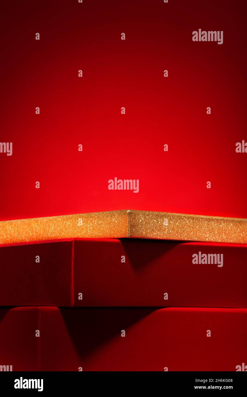 Majestätisches leeres rotes Podium aus Geschenkschachteln Roter Hintergrund .Pedestal, Schaufenster für Produkte und Kosmetik. Chinesisches Neujahrskonzept Copy Space, Verti Stockfoto