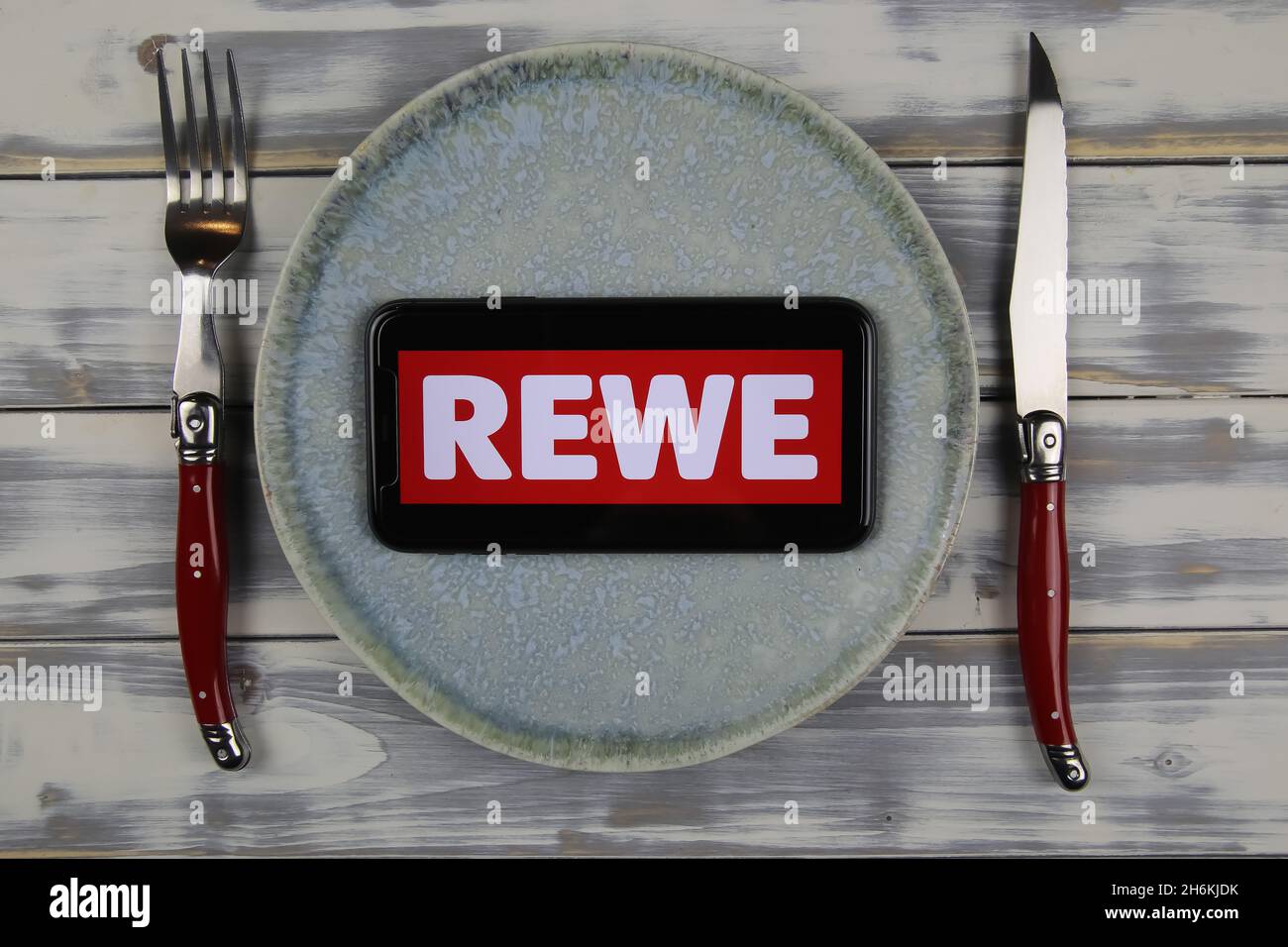 Viersen, Deutschland - Juni 9. 2021: Nahaufnahme des Handybildschirms mit Logo-Schriftzug von Rewe auf dem Teller (Fokus auf der Mitte des Telefonbildschirms) Stockfoto