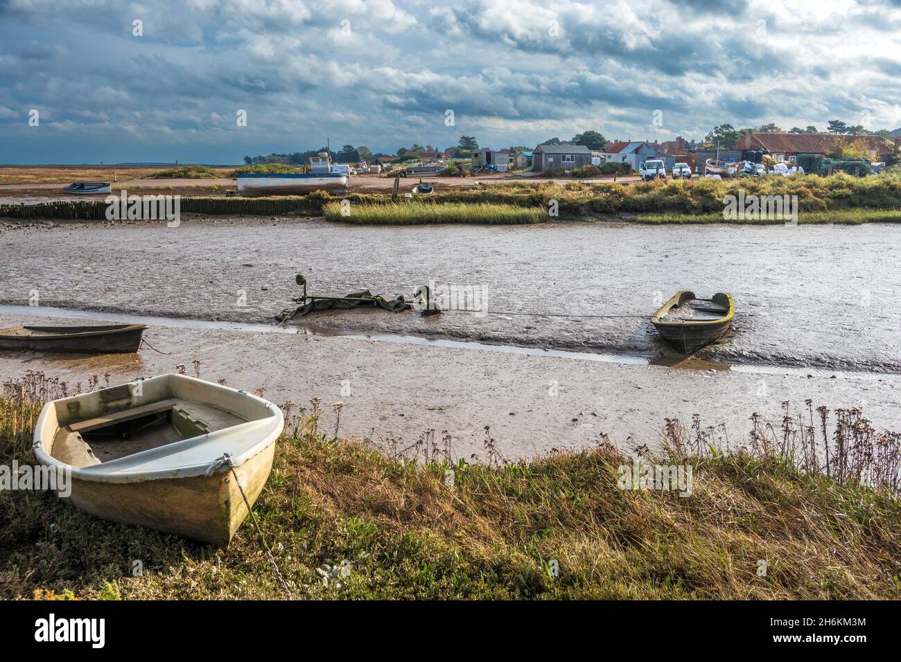 Ebbe mit Booten im Schlamm am Mow Creek Brancaster Staithe Harbour North Norfolk England Stockfoto
